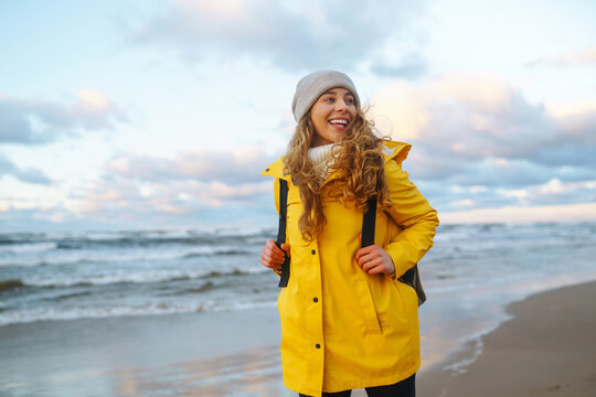 Happy Tourist In A Yellow Jacket Standing And Looking On Sea. Lifestyle, Travel, Tourism, Nature, Active Life.