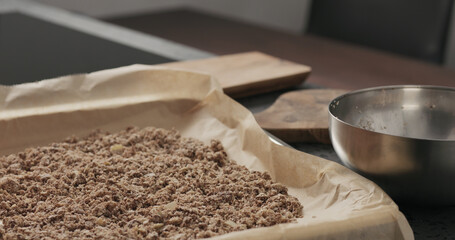 Slow motion making granola, spread on baking sheet
