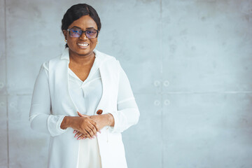 Obraz premium Happy smiling African American woman in formal isolated on gray background. Headshot of an african american businesswoman, CEO, finance, law, attorney, legal, representative