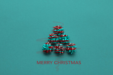 christmas tree with metallic mini rosettes in green/red, background green, with text: merry...