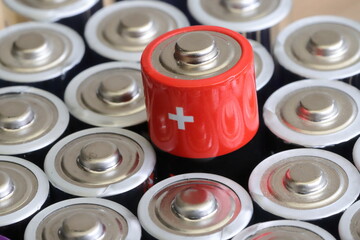 many round batteries and one red battery - obrazy, fototapety, plakaty