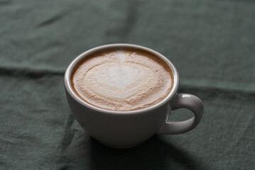 Fresh flat white coffee in white cup on linen cloth