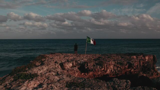 silhouette man with waving flag of Mexico at beach on.