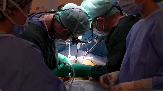 Surgeons perform heart surgery with special magnifying operating glasses in the operating room