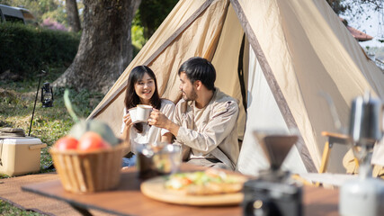 Young couple camping weekend in the woods near river, Enjoying Camping Holiday In Countryside, Leisure activities, Dating and relaxation in nature, Couple dripping coffee and sipping coffee.