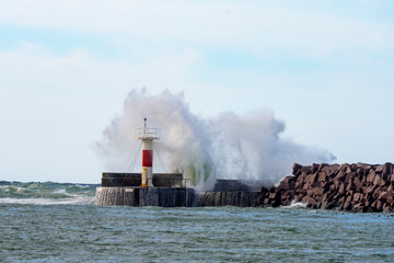 Fototapeta na wymiar Stormy sea crashing into a harbor jetty