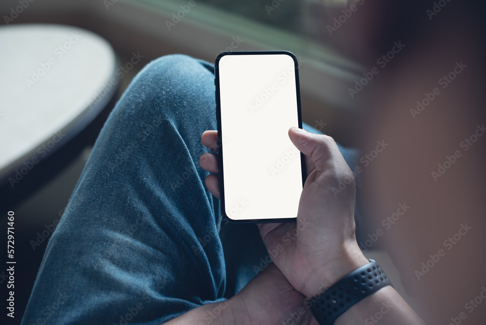 Wall mural Mockup of mobile phone for advertising. Mock up image of man hand holding and using smartphone with blank screen for mobile app design or text advertisement