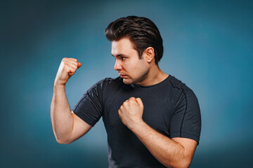 Young brunette man fighter on blue background