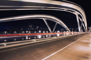Aufnahme eines Br&uuml;ckenbogen mit einem Lichtstreifen auf der Fahrbahn