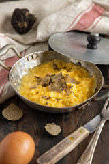 Scrambled eggs with fresh black truffles from Italy served in a frying pan, gourmet breakfast