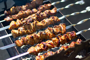 Juicy meat is grilled on the grill in the summer. Marinated meat on fire. Rest, delicious food