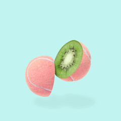 A cheerful pink tennis ball with a slit and a kiwi inside. Minimal sureal collage in the style of pop art as a concept of sports food and healthy fruits. High quality photo