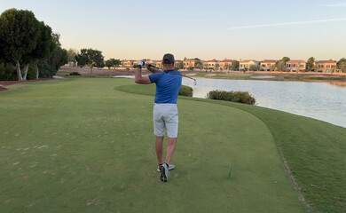 Male golfer golfer hitting golf ball from tee