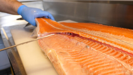 Cutting fresh raw Norwegian salmon fish