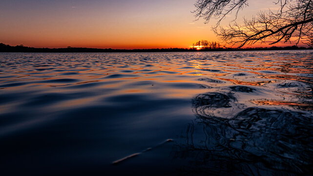 z tapli wody przy zachodzącym słońcu
