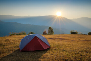 camping in the mountains, tourist tent camping in mountains at sunrise