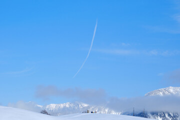 winter landscape with snow and a contrail