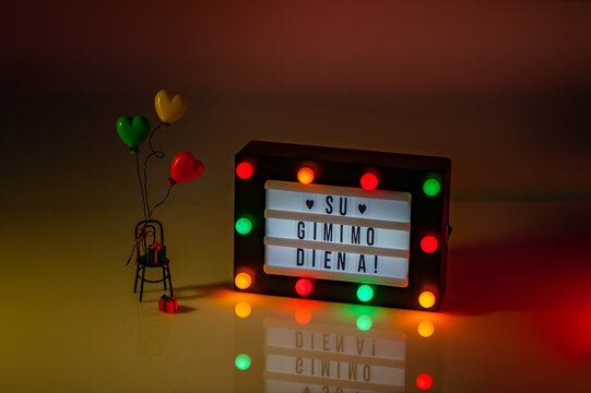 Flag of Lithuania in the shape of a hearts with Happy Birthday ("Su gimimo diena") written in lightbox. Independence Day Concept. - Powered by Adobe