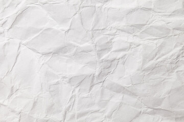 Crumpled white paper wrapping with corrugations and fractures, uneven surface, background texture, close-up