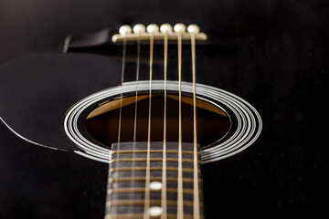 Obraz premium Guitar black, polished smooth soundboard, stretched strings, close-up selective focus