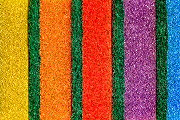 Foams rubber multicolored sponge for washing dishes, pores close-up macro background wallpaper, uniform texture pattern