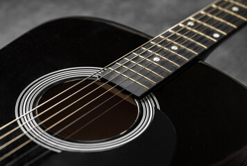 Guitar black, polished smooth soundboard, stretched strings, copper frets on neck, close-up...