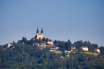 The Pilgrimage Church of Linz, Austria as seen from the Danube River. - 572993233