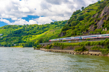 Fototapeta premium Intercity express train IC in Rhein Rhine river in Loreley, Rhein-Lahn-Kreis, Rhineland-Palatinate, Rheinland-Pfalz, Germany