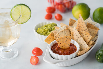 Crispy homemade keto diet tortilla chips served with cold beverage and dips.