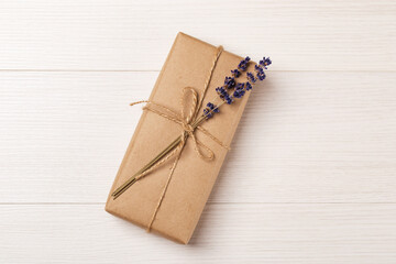 Obraz na płótnie Canvas Craft gift box with lavender bouquet on a white wooden table. Eco-friendly concept. Rustic style. Romantic concept for presents.