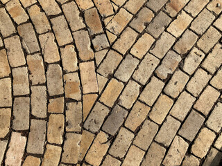 Yellow brick road. Yellow stone tiles masonry closeup background. the texture of yellow antique paving stones. Old yellow pavement in a pattern.