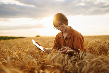 Young Female farmer with tablet in the field. Agriculture, gardening, business or ecology concept....