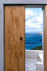 Traditional greek, beautiful brown wooden door above aegean sea Caldera on Santorini island, Greece. View to the sea through door, from Santorini