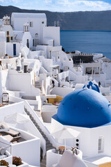 Fototapeta na wymiar Traditional greek famous white architecture and blue domes on Oia, Santorini island, Greece. 
