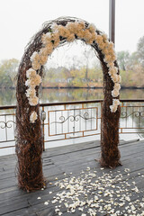 Wedding ceremony in nature with an arch decorated with white flowers