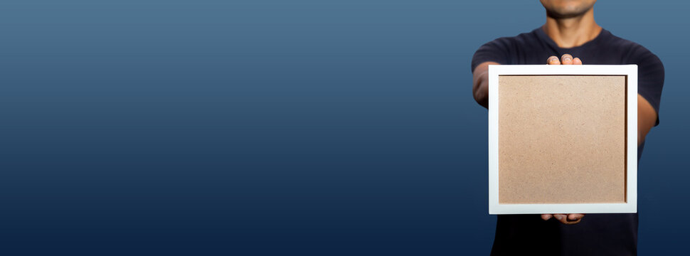 HOMBRE CON UN MARCO VACIO PARA TEXTO EN SUS MANOS, EN FONDO DEGRADADO Y ESPACIOS PARA PONER TEXTO  