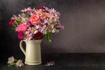 Beautiful fresh flowers. Pink bouquet of flowers in vase, on black background.