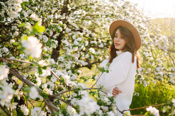 Young beautiful woman relaxing in blooming  garden. Spring,  romantic and lifestyle concept.