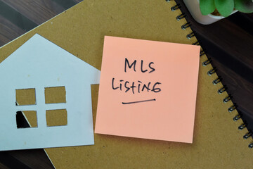 Concept of MLS Listing write on sticky notes isolated on Wooden Table.