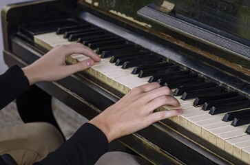 Fototapeta premium hands on piano keyboard close up black and white keys
