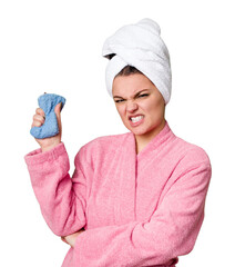 A woman stands with a pink bathrobe and towel wrapped around her wet hair, holding a sponge tightly with a look of frustration - obrazy, fototapety, plakaty