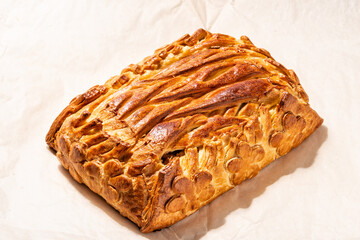 Homemade apple pie with cinnamon on baking paper on a plate.