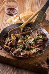 Traditional French venison ragout witch mushroom in Burgundy red wine sauce served as close-up in a...