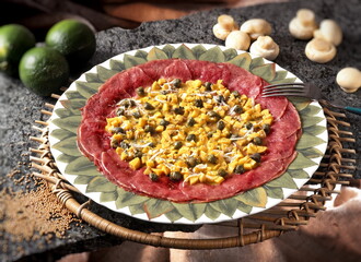 carpaccio with diced mushrooms, raw meat and capers and lemon