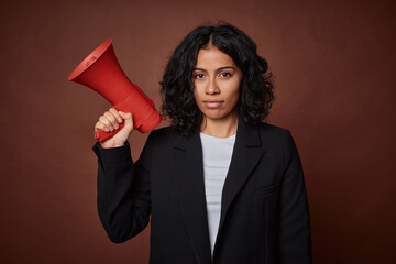 A young business woman passionately advocates for her rights with a megaphone.