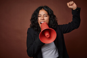 A young business woman passionately advocates for her rights with a megaphone.