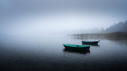 foggy morning view of the lake and two boats