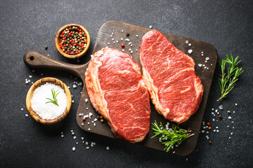 Fototapeta na wymiar Raw beef meat. Fresh meat steaks at black board. Top view.