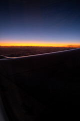 Fluoretic and pink sunset in the sky above the wing of the aircraft