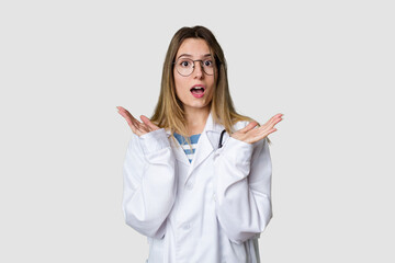Compassionate female physician with a stethoscope around her neck, ready to diagnose and care for her patients in her signature white coat surprised and shocked.